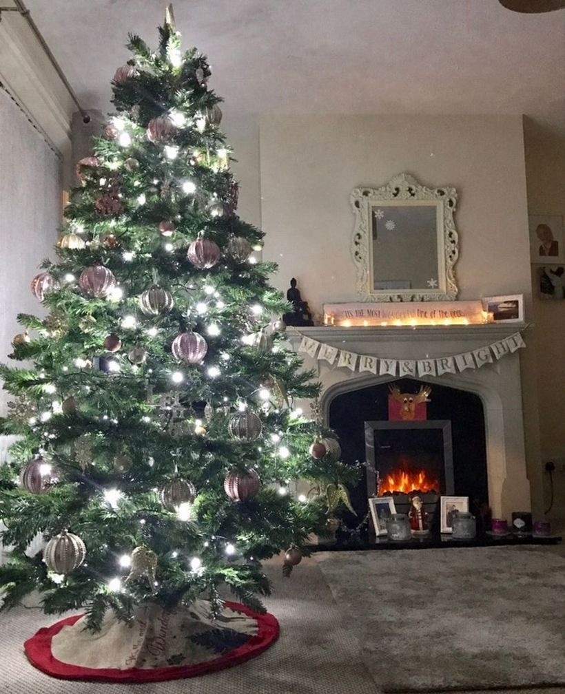 Big green chrismast tree with white light and white ornament