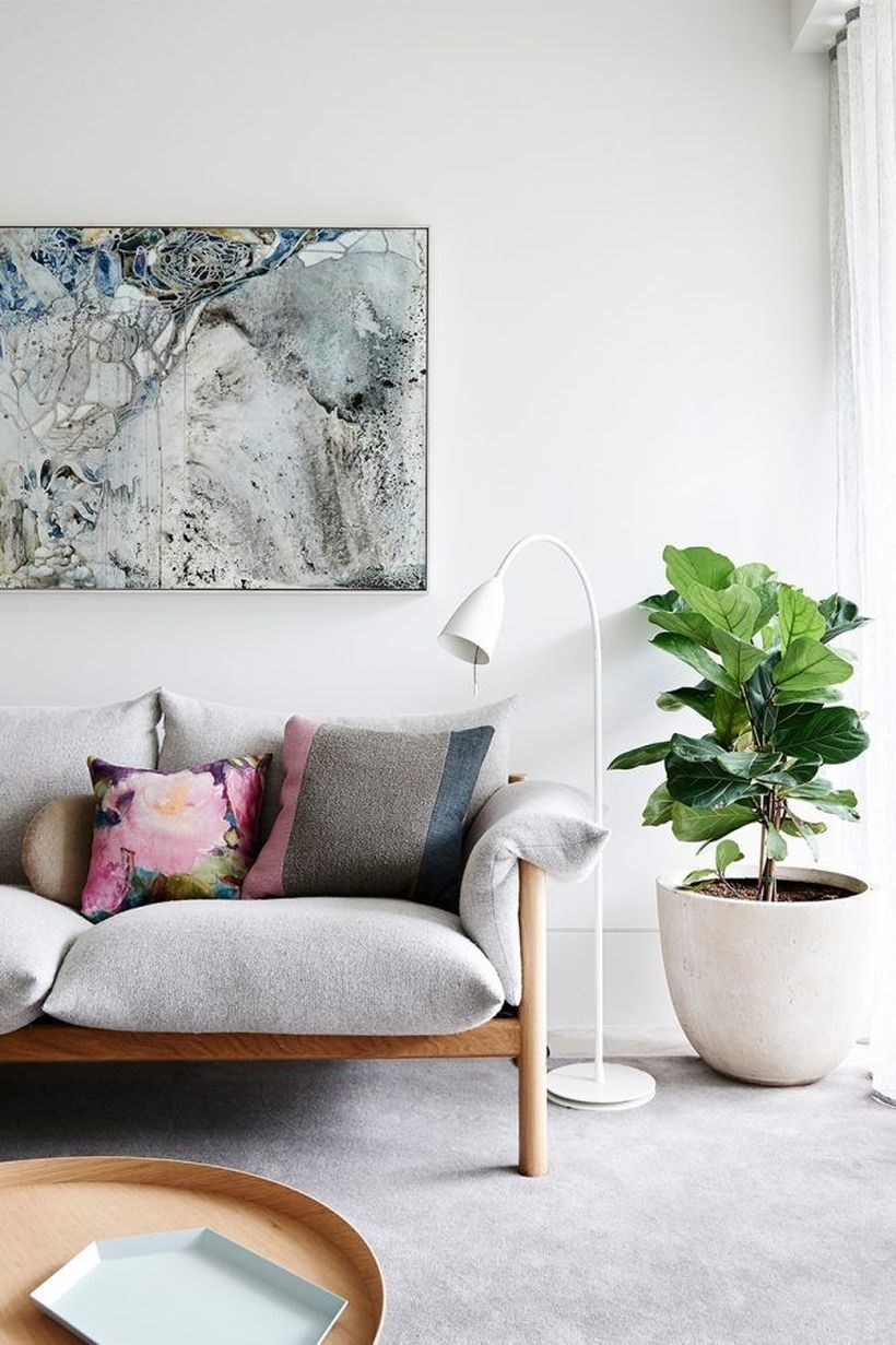 Colorful cushion with flower pattern above white sofa