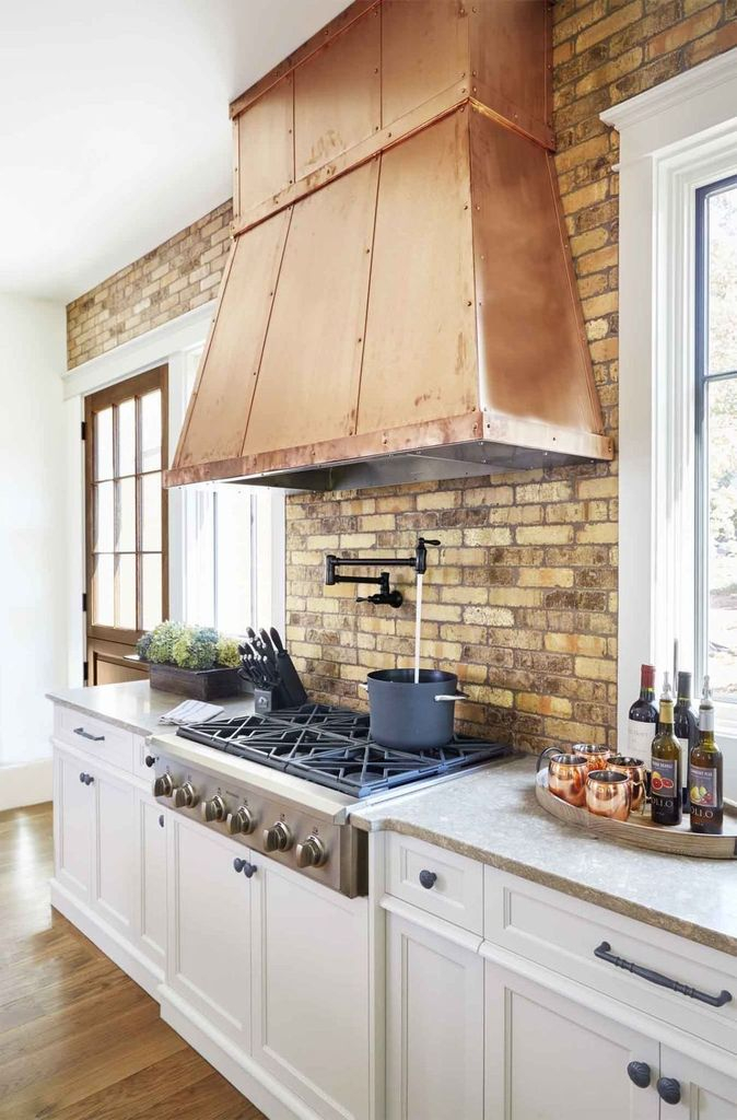 Kitchen design with brick walls and white cabinets