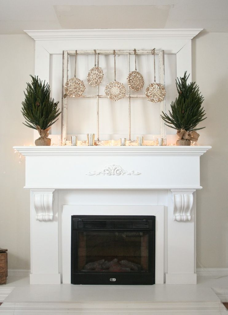 White fireplace with small tree and hanging gold decoration