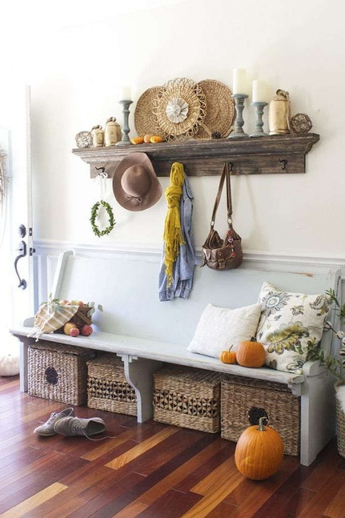 A cozy fall farmhouse entryway with a shabby chic bench, a stained open shelf, basket boxes for storage and candles