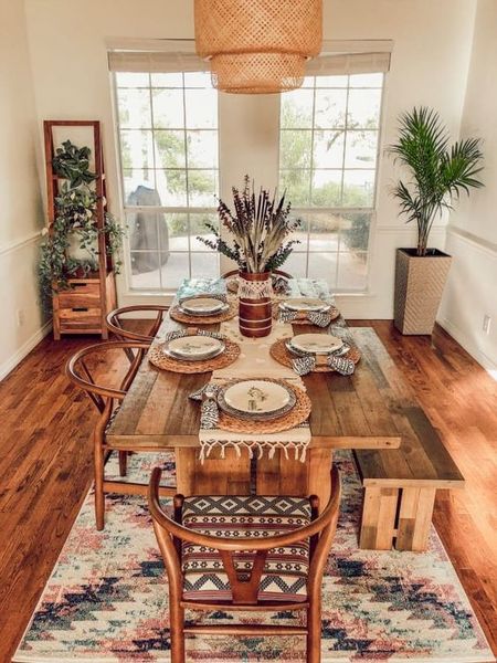 A-gorgeous-boho-dining-space-with-potted-greenery-a-boho-rug-a-wicker-pendant-lamp-and-warm-stained-furniture