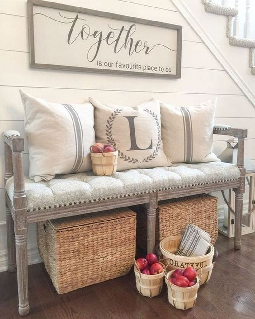 A vintage upholstered farmhouse bench, woven boxes, a sign and some wooden baskets