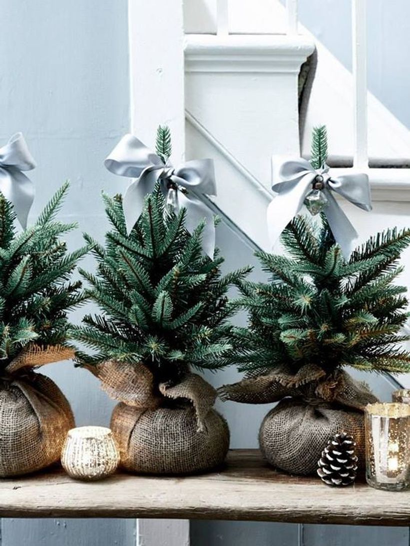 08-a-trio-of-little-christmas-trees-wrapped-in-burlap-and-topped-with-grey-ribbon-bows-for-a-cute-look