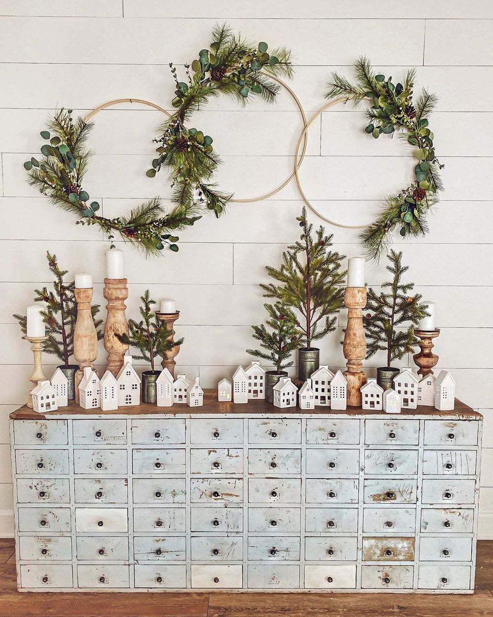 Farmhouse-winter-console-table-decor-with-white-houses-and-evergreen-hoops-via-@cottonstem-1