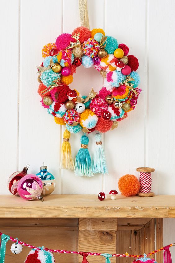03-a-super-colorful-and-whimsy-holiday-wreath-with-pompoms-ornaments-fake-mushrooms-and-large-tassels
