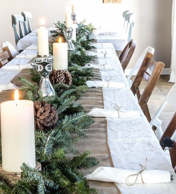 07-a-burlap-table-runner-an-evergreen-garland-candles-and-large-pinecones-for-a-cozy-rustic-feel