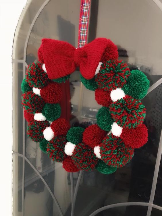 2-07-a-christmas-pompom-wreath-of-white-green-and-red-pompoms-and-a-knit-bow