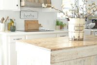 A-farmhouse-kitchen-with-a-reclaimed-wood-hood-a-shabby-chic-kitchen-island-and-all-white-everything
