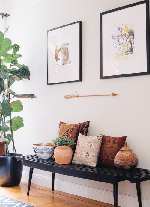 02-a-black-bench-colorful-pillows-potted-plants-artworks-and-an-arrow