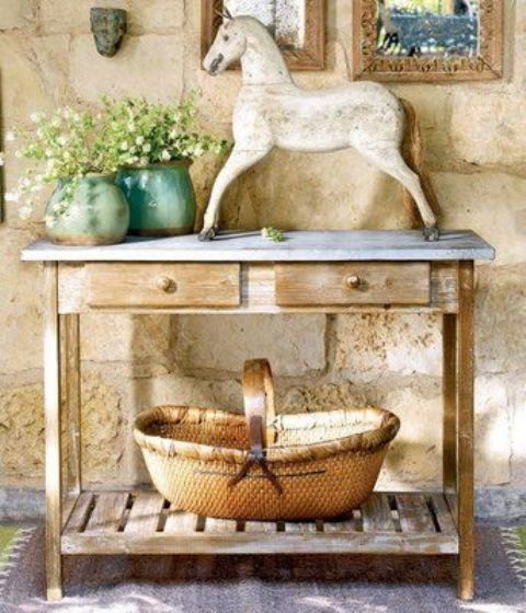 02-a-rustic-console-table-with-a-large-basket-a-statuette-and-some-potted-flowers