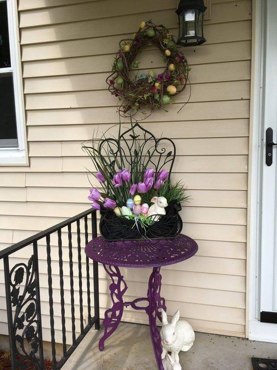 A-vine-wreath-with-colorful-eggs-potted-blooms-and-faux-eggs-in-a-planter-fake-bunnies-for-porch-decor