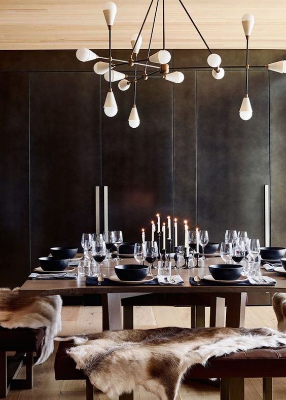 A-moody-modern-chalet-dining-space-with-black-walls-dark-modenr-furniture-a-catchy-chandelier-and-candles