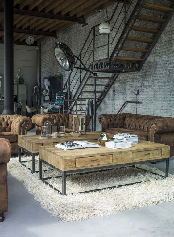 An-industrial-living-room-with-whitewashed-brick-walls-leather-tufted-sofas-wood-and-metal-coffee-tables