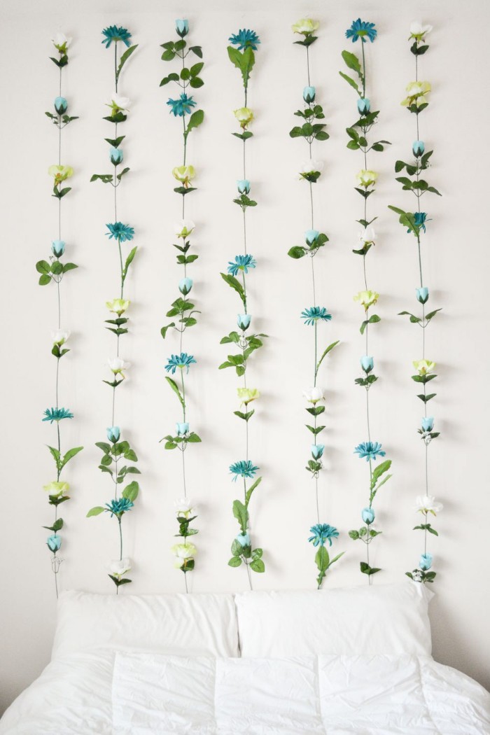 Handmade-faux-flower-wall-decoration-in-green-cream-and-teal-mounted-on-a-white-wall-near-a-bed-diys-for-girls