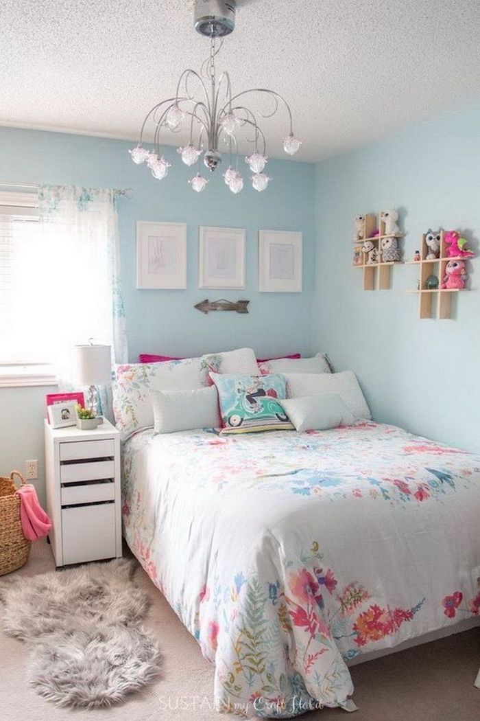 Light-blue-walls-teen-girl-room-decor-colorful-throw-pillows-silver-chandelier-small-wooden-bookshelves-on-the-wall