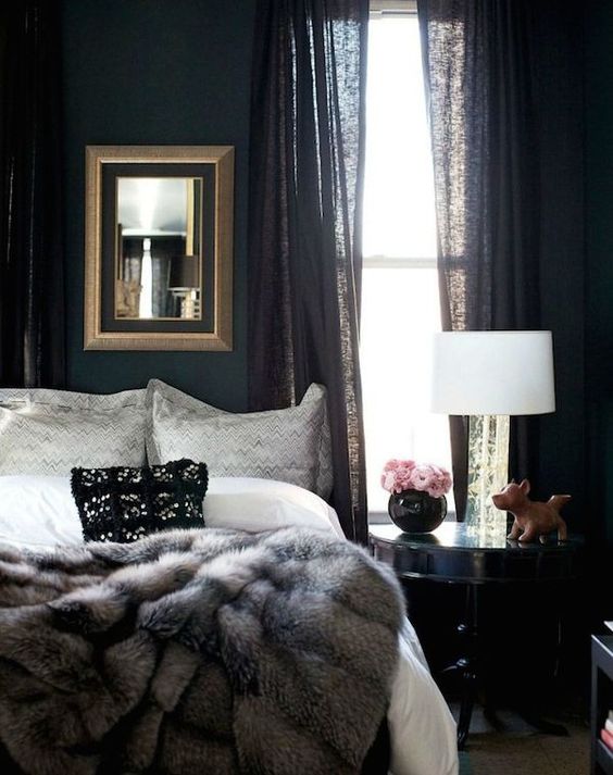Moody-bedroom-with-black-curtains-a-fur-blanket-and-a-framed-mirror