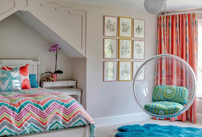 Round-swing-made-from-clear-plastic-in-a-room-with-white-walls-a-window-with-orange-patterned-curtains-nine-framed-artworks-cute-teen-rooms