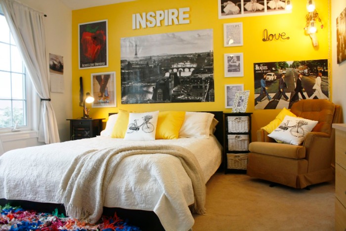 Yellow-wall-with-posters-and-framed-images-in-a-room-with-a-brown-armchair-a-large-bed-and-a-window-with-white-curtains-cool-beds-for-teens