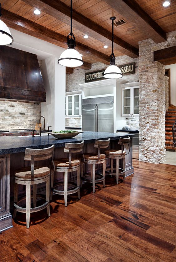 04-a-rustic-kitchen-with-a-rich-colored-wood-floor-and-whitewashed-vintage-wooden-chairs