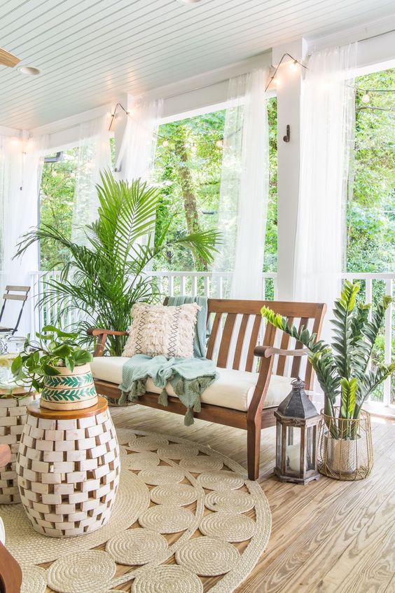 1-a-tropical-boho-porch-with-wooden-furniture-jute-rugs-lots-of-potted-greenery-and-candle-lanterns