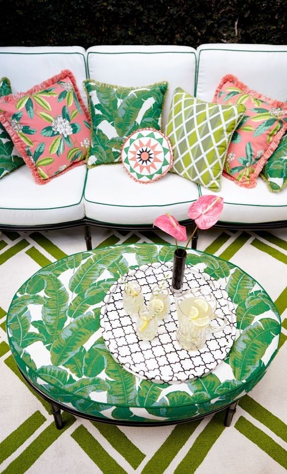 2-26-make-up-a-boho-patio-with-a-large-neutral-sofa-with-colorful-pillows-and-a-tropical-leaf-print-table