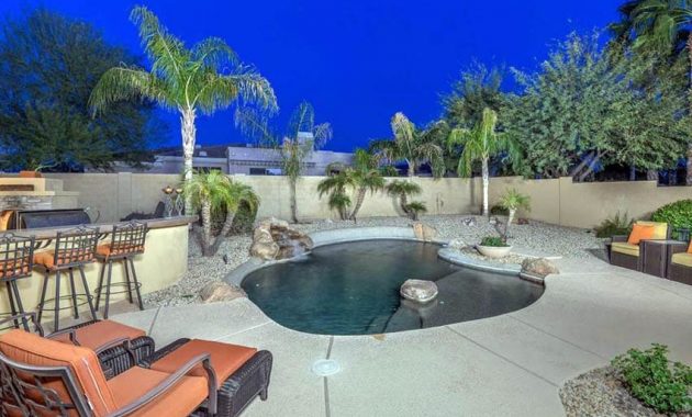 2-oasis-swimming-pool-with-rock-islands-next-to-outdoor-kitchen-and-tropical-landscaping