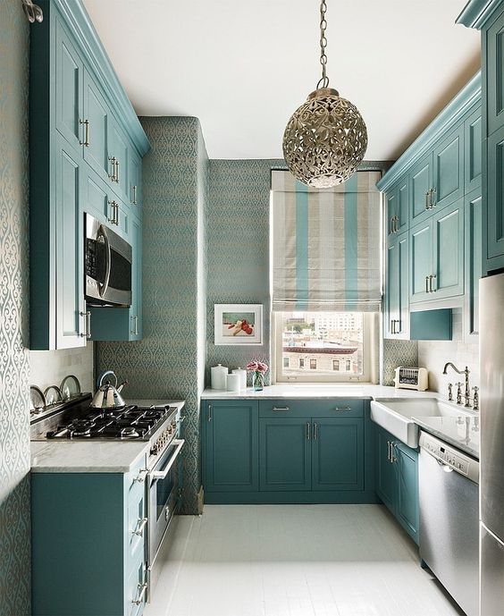A-beautiful-turquoise-kitchen-with-white-countertops-a-window-instead-of-a-backsplash-and-vintage-faucets
