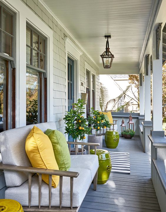 1-a-bright-and-welcoming-summer-porch-with-citrus-trees-a-neutral-loveseat-with-bright-pillows-and-side-tables