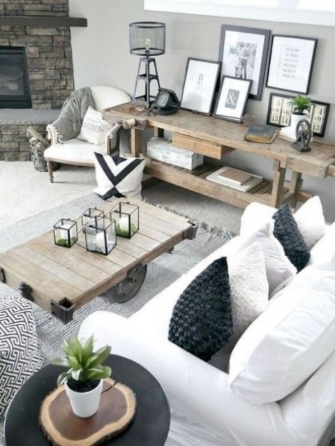 2-a-stylish-farmhouse-living-space-with-rough-wooden-tables-white-upholstery-some-prints-and-a-faux-stone-clad-fireplace