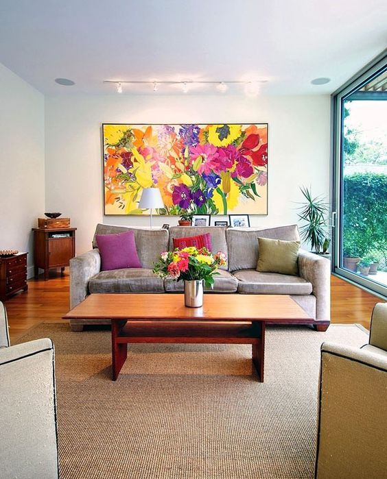 A-bold-floral-artwork-bold-blooms-in-a-vase-and-colorful-pillows-to-make-your-living-room-extra-bold