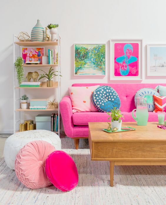 A-bold-living-room-with-colorful-artworks-a-pink-sofa-and-pink-and-blush-pillows-plus-printed-ones