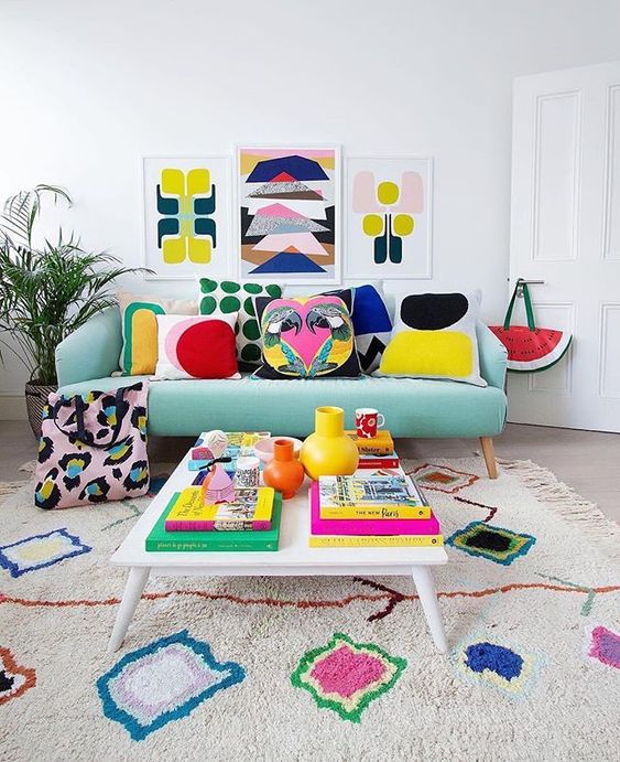 A-bold-summer-living-room-with-a-colorful-gallery-wall-bright-printed-pillows-and-a-rug-plus-bright-books-and-vases