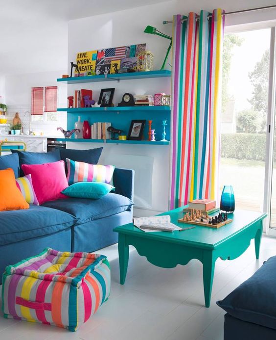 A-bright-living-room-with-striped-curtains-a-matching-ottoman-colorful-pillows-and-some-bold-furniture-for-fun