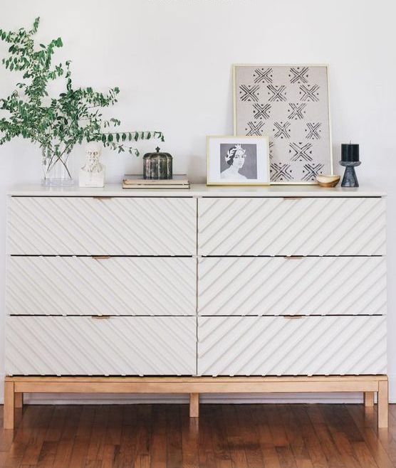 A-trendy-tarva-dresser-hack-with-striped-wall-panels-light-colored-stained-legs-and-a-frame-and-brass-pulls