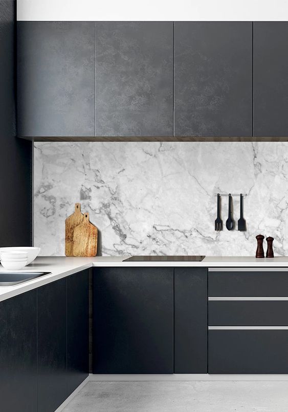 03-a-black-minimalist-kitchen-with-sleek-cabinets-neutral-stoen-countertops-and-a-white-marble-backsplash