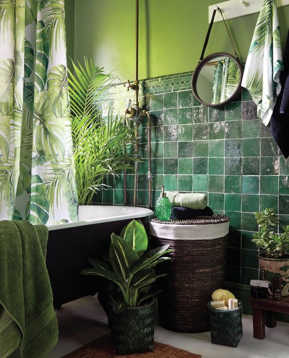 1-a-moody-tropical-bathroom-with-green-walls-and-dark-green-glossy-tiles-a-black-tub-a-woven-stool-potted-plants-and-tropical-print-textiles