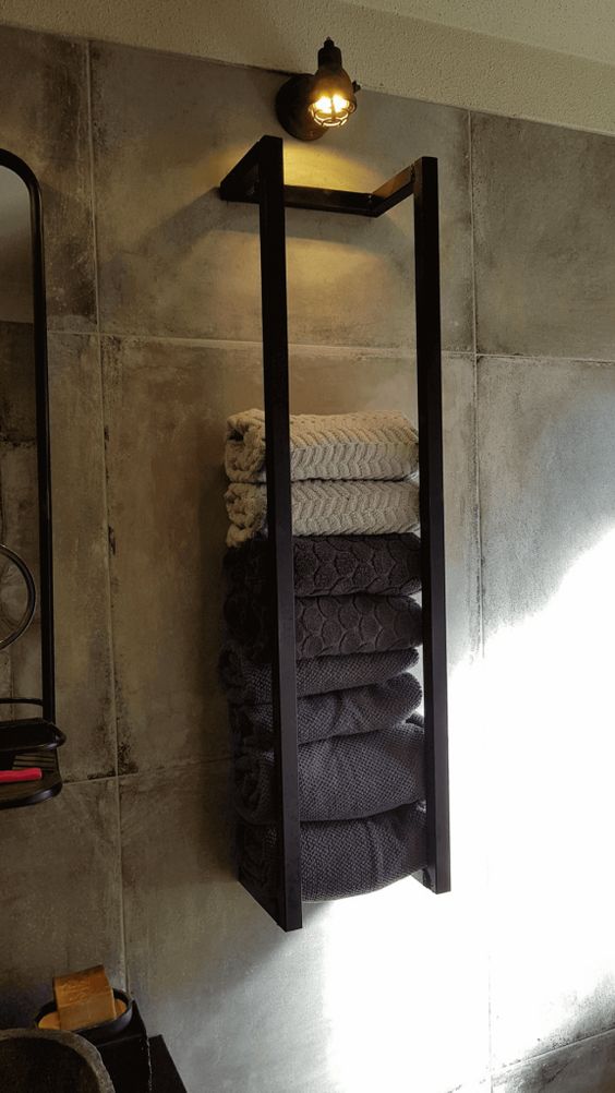 12-an-industrial-black-metal-wall-mounted-shelf-with-various-towels-and-a-light-over-it-is-a-stylish-idea-to-store-stuff