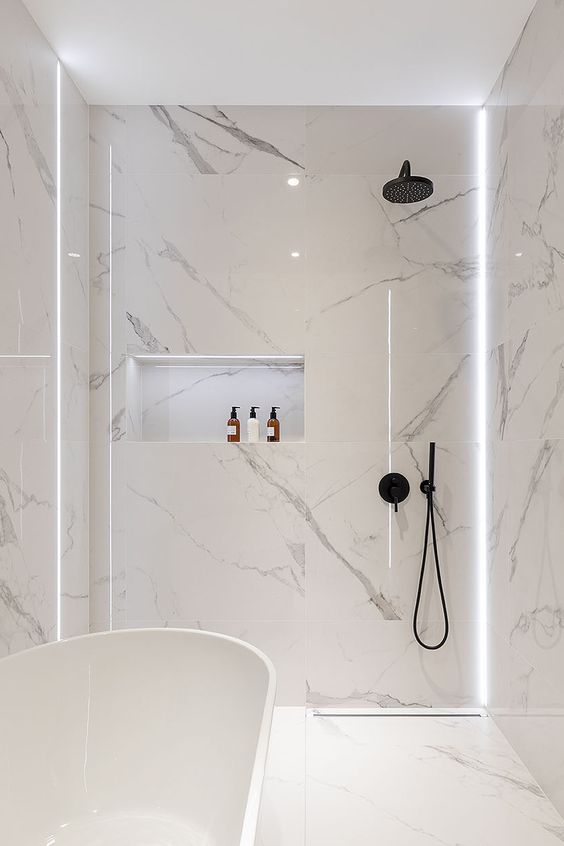 20-a-minimalist-white-bathroom-fully-clad-with-marble-with-a-tub-and-a-shower-plus-built-in-lights-for-a-refined-feel