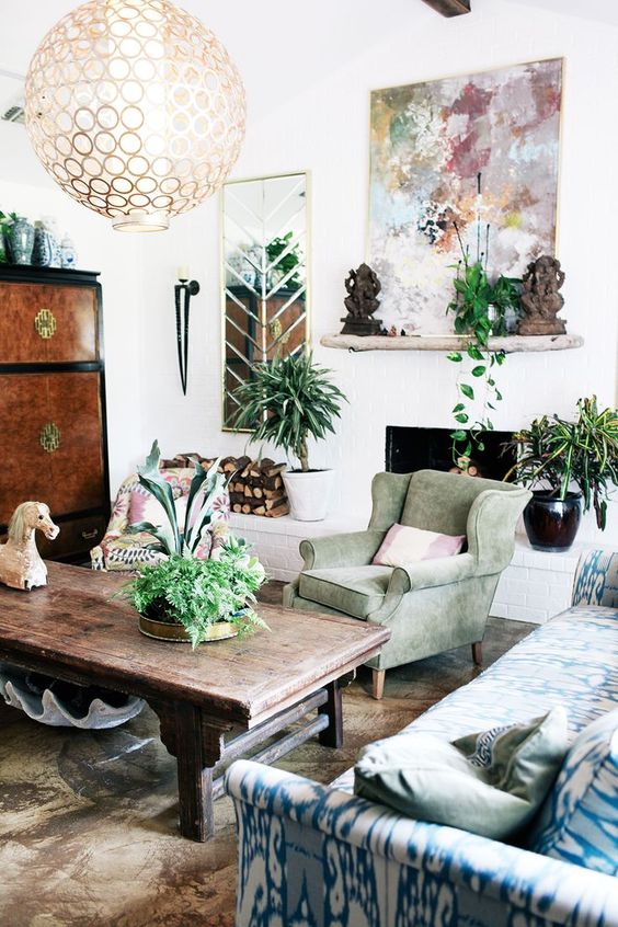 39-a-bright-eclectic-living-room-with-pastel-living-room-a-fireplace-potted-greenery-and-a-sphere-chandelier