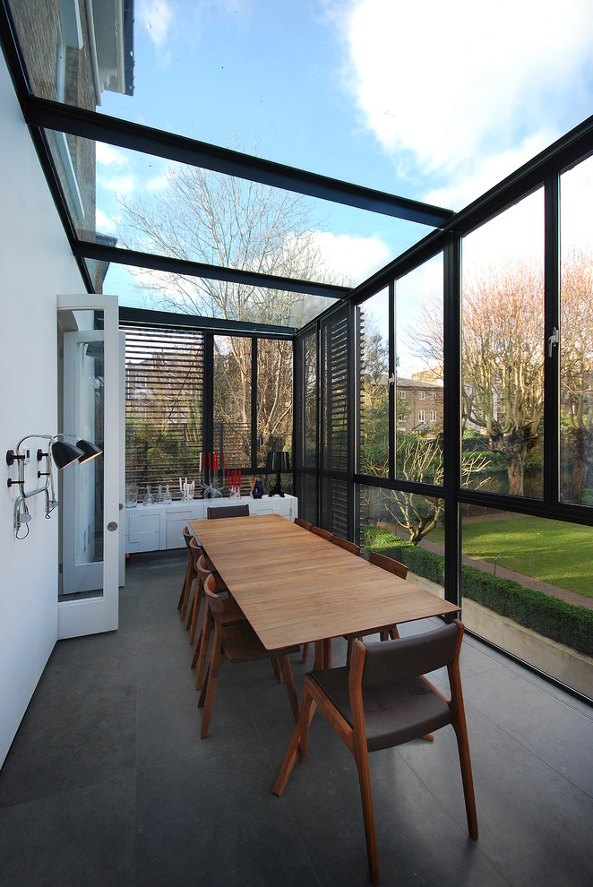 Contemporary-narrow-sunroom-extension-that-features-black-shutters