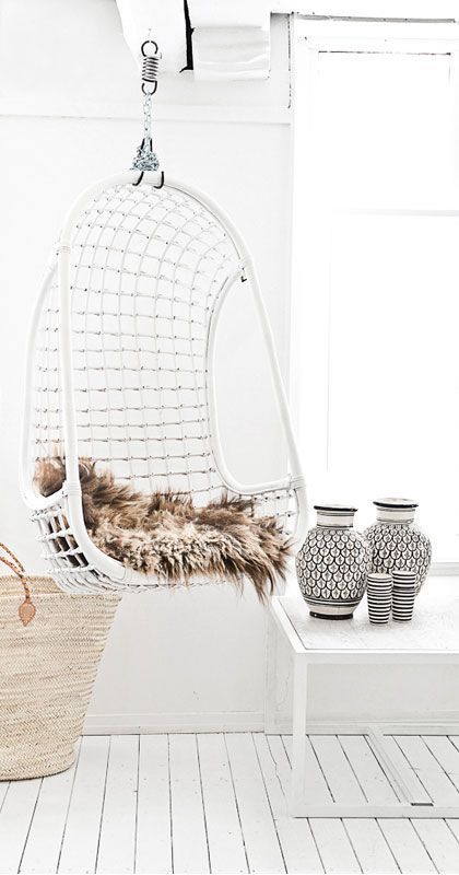 07-a-white-wicker-hanging-chair-with-faux-fur-for-a-scandinavian-interior