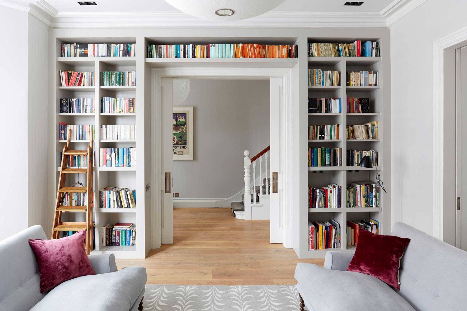 1-bookshelf-that-wraps-itself-around-the-doorway-helps-create-a-lovely-wall-of-books-in-the-living-room-with-ample-natural-light