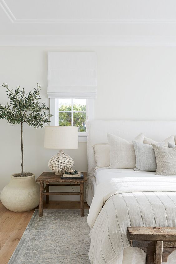 1-a-neutral-bedroom-with-a-white-upholstered-bed-neutral-pillows-a-white-lamp-and-white-shades-plus-a-statement-plant