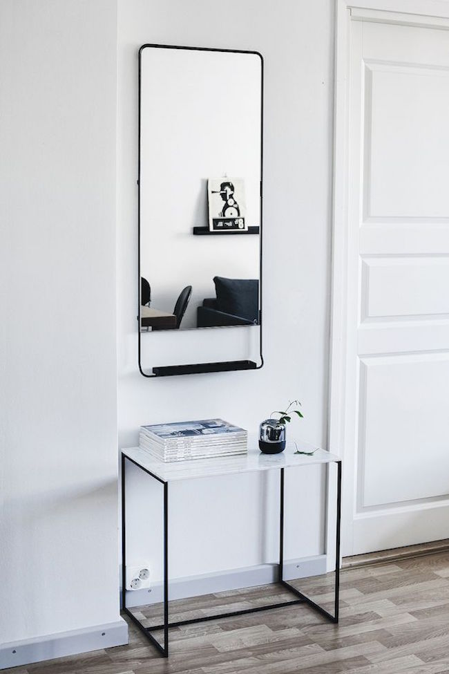 A-scandinavian-entryway-with-striking-charcoal-tones-for-the-mirror-and-table