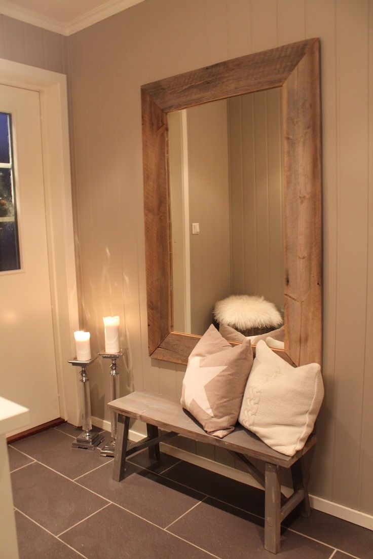Large-framed-mirror-hung-above-rustic-wood-bench