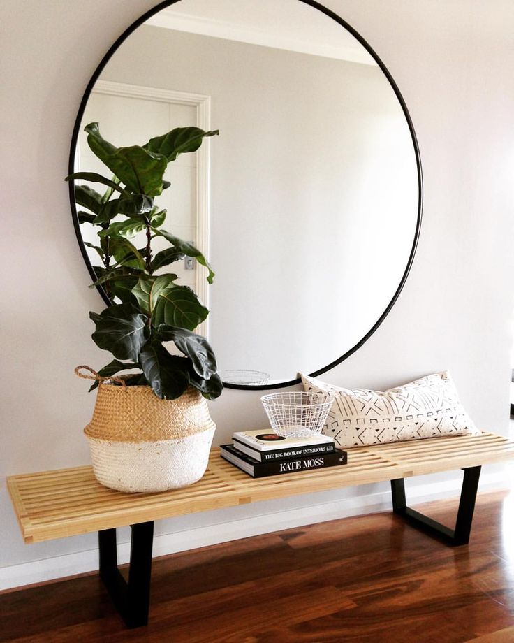 Large-round-mirror-above-a-wood-bench