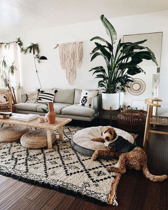 A-bohi-chic-living-room-with-a-printed-rug-and-pillows-a-macrame-hanging-potted-plants-and-jute-ottomans