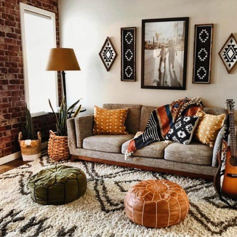 A-boho-living-room-with-folksy-artworks-and-pillows-leather-and-velvet-ottomans-potted-plants-and-a-comfy-sofa
