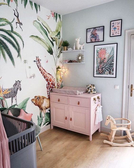 A-bright-tropical-nursery-with-a-pink-changing-table-a-bright-jungle-print-wall-bright-artworks-and-a-grey-crib-with-a-pink-canopy